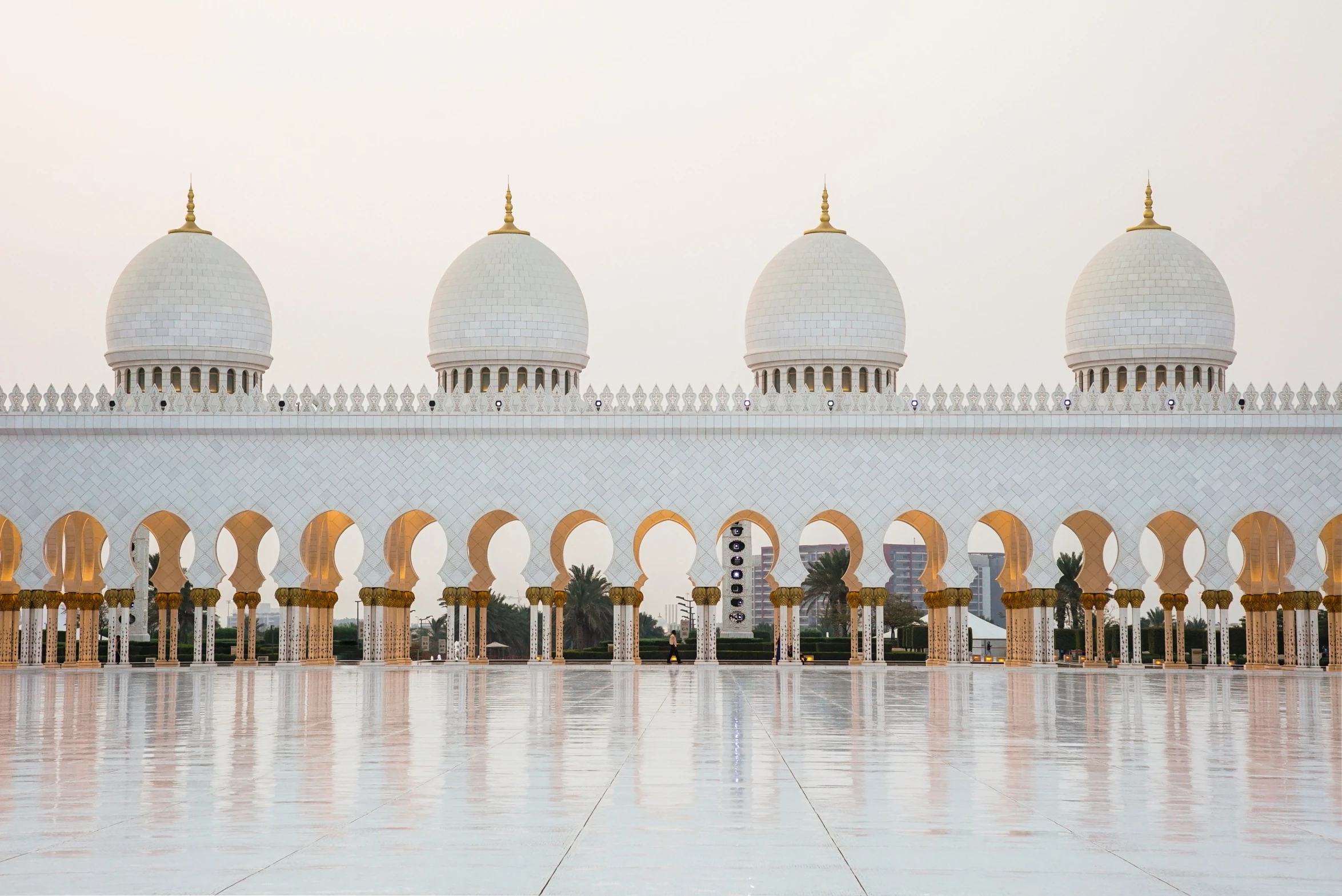 a picture taken outside a white building with multiple arches on the water