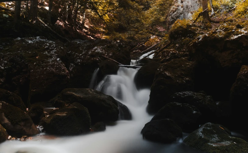 waterfall cascading down from the top of rocks in a forest