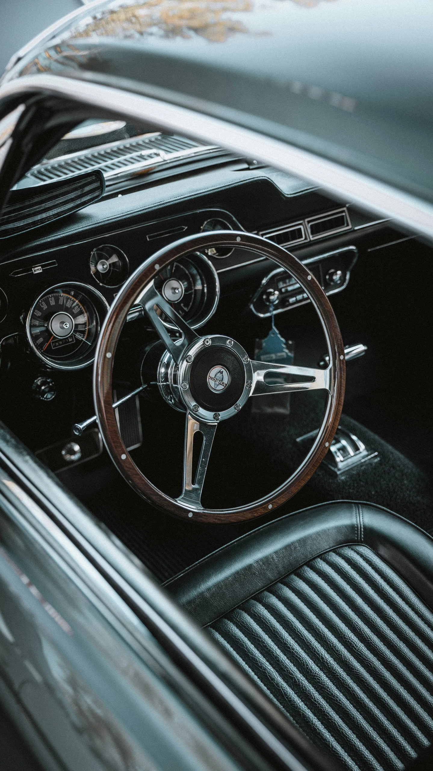 an old car dashboard with leather and silver trim