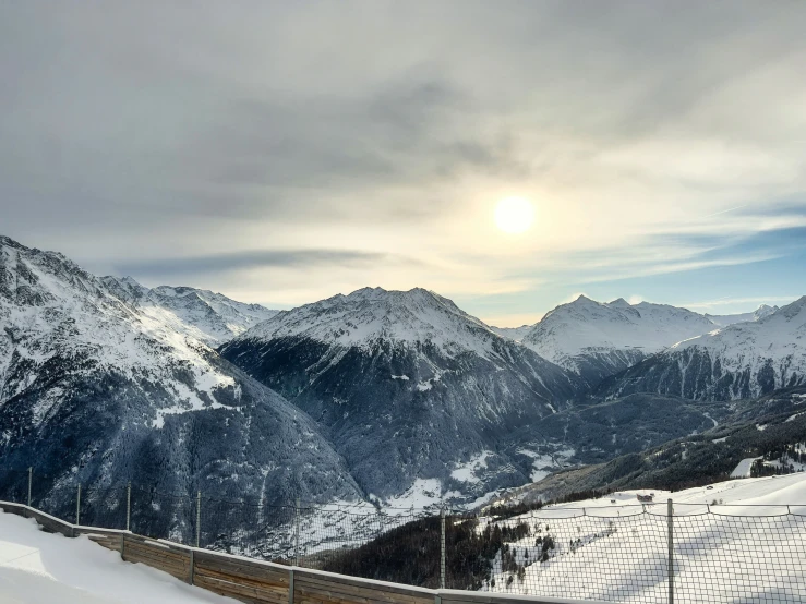 a long fence on top of a snow covered mountain