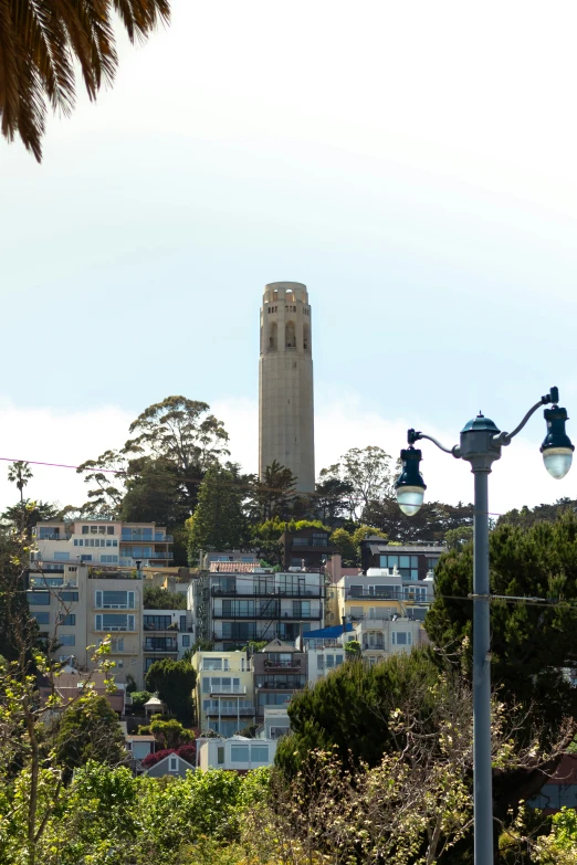 a tall tower standing behind the city with many windows