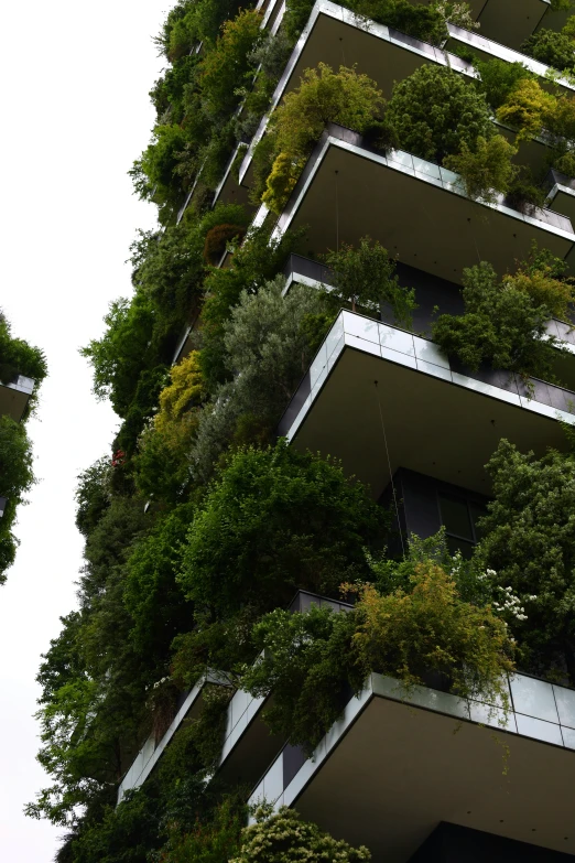 a tall building with lots of green trees on it