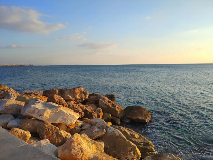 some very pretty rocks by the water by some sand