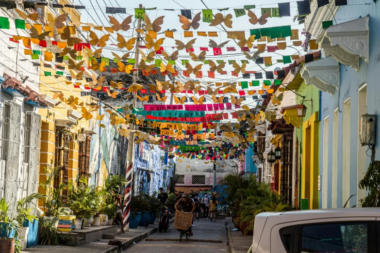 people walking down an alley lined with buildings and decorations