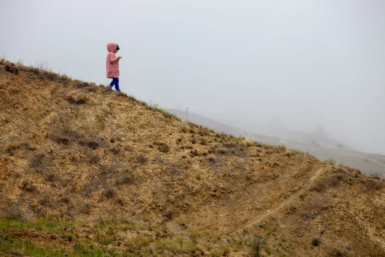 man standing at the top of a hill overlooking the view