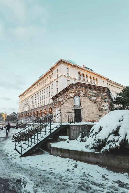 snowy landscape with people walking up to a building