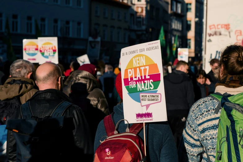 many people with signs walk in the street