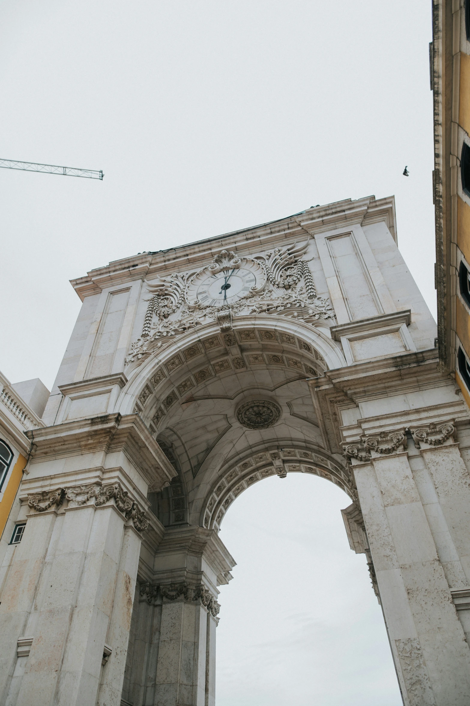 a tall white arch above a street near buildings