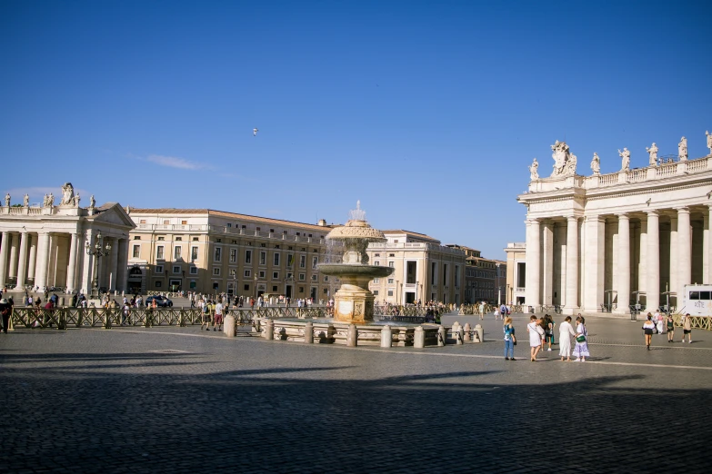 a crowd of people are standing outside by an ornate fountain