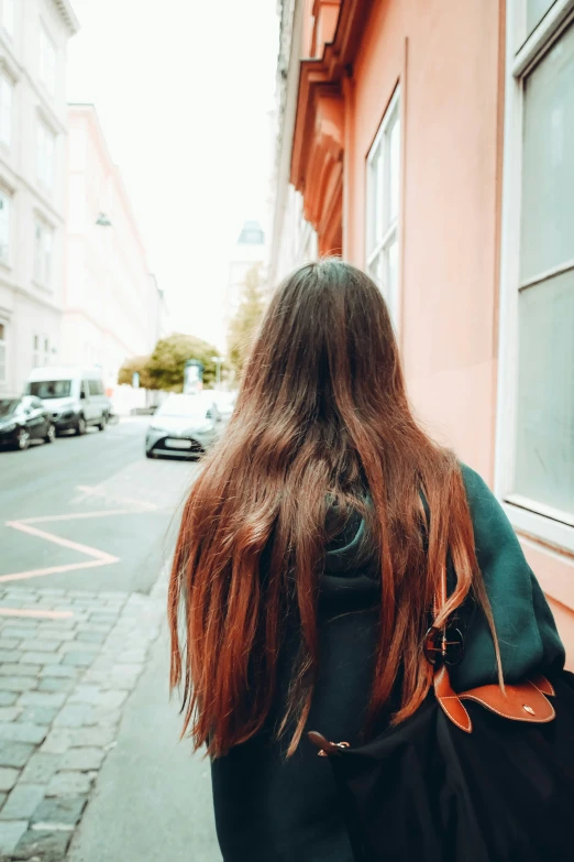 the back view of a girl standing in front of a building