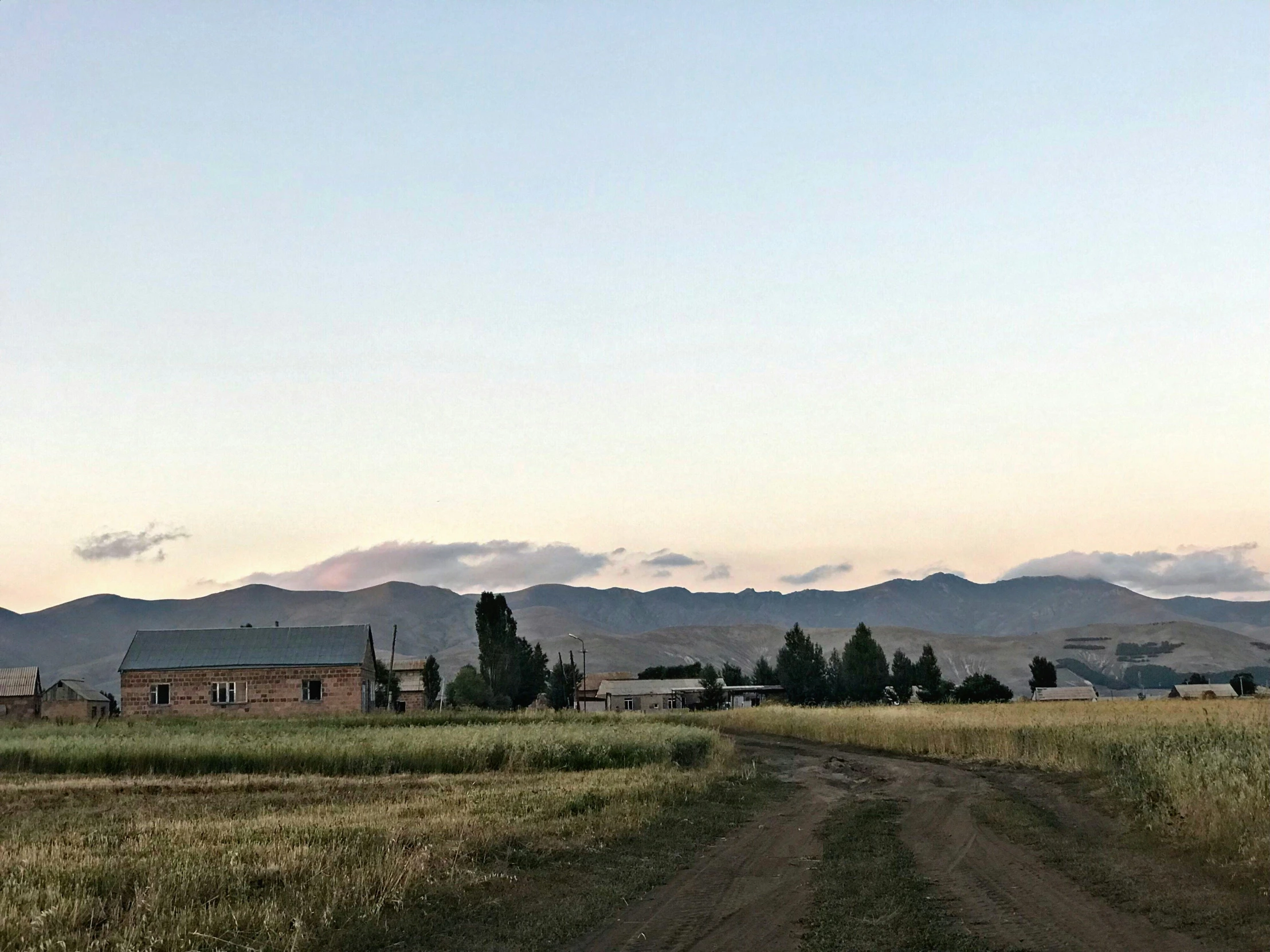 the view of the mountains from a dirt road