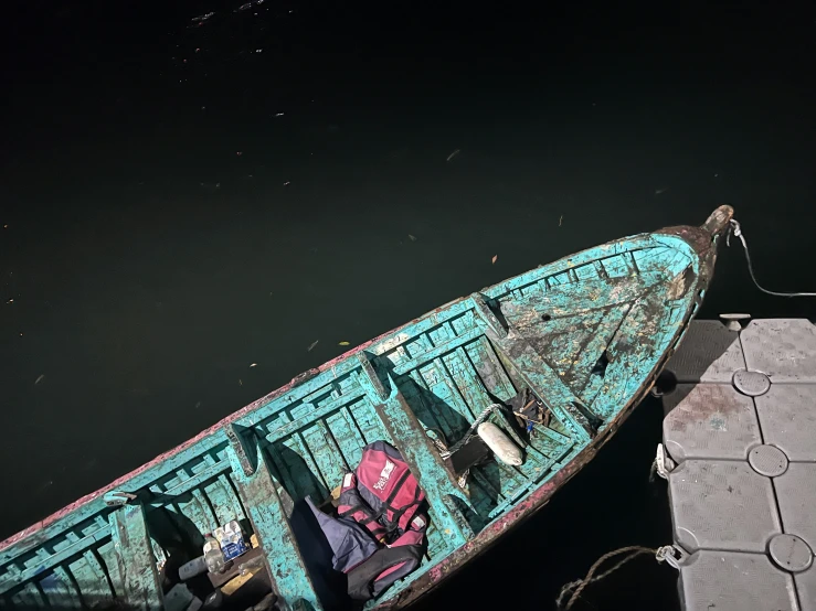 the blue boat is docked on the water by a dock