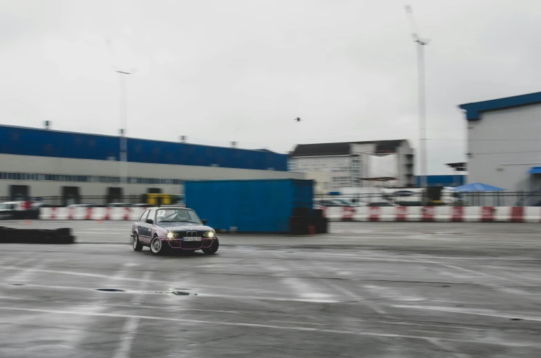 a mini car drives in front of a building