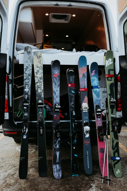 a white van is packed up with many different snowboards