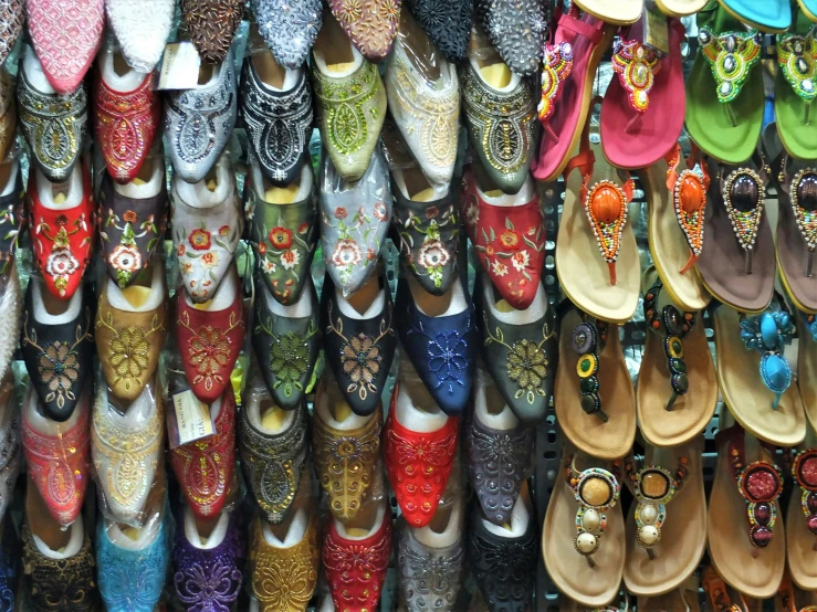 many sandals hanging up on hooks in a store