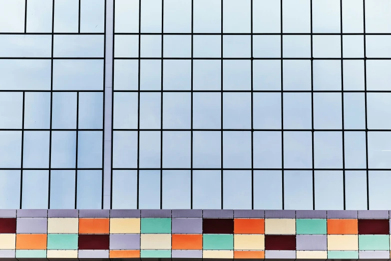 a multicolored bench next to tall brick building