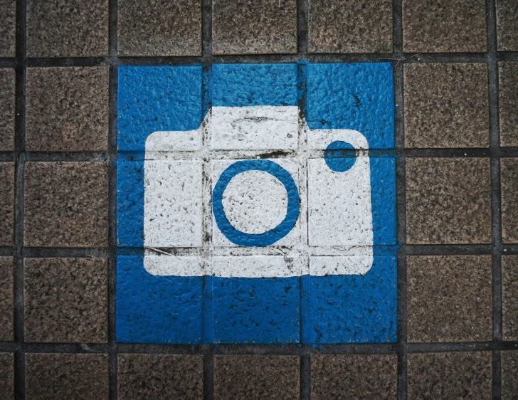 a close up of a tile with the logo of a camera