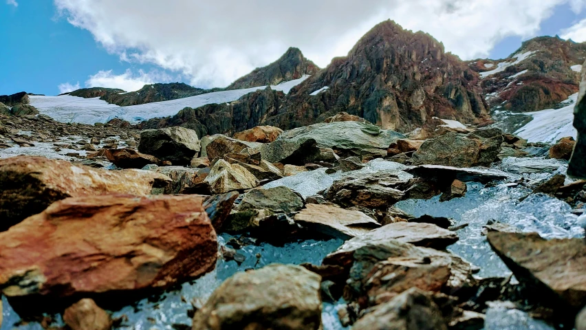 a person is walking on some rocks in the mountains