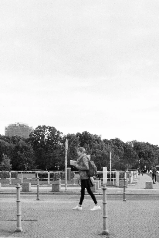 a man in grey jacket flying a kite in park area