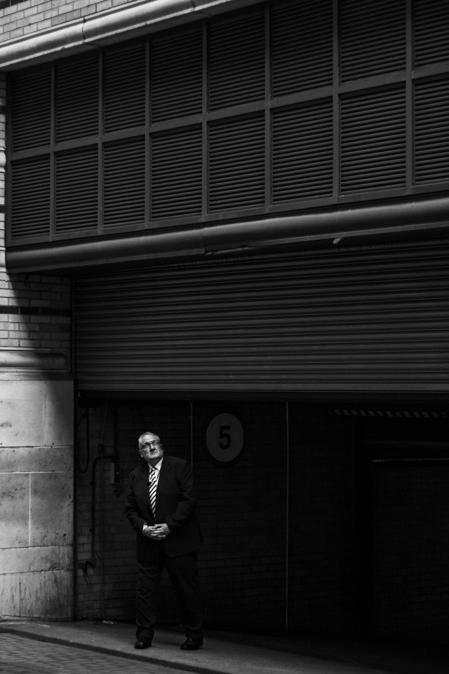 the man standing on the street is dressed in a suit and tie