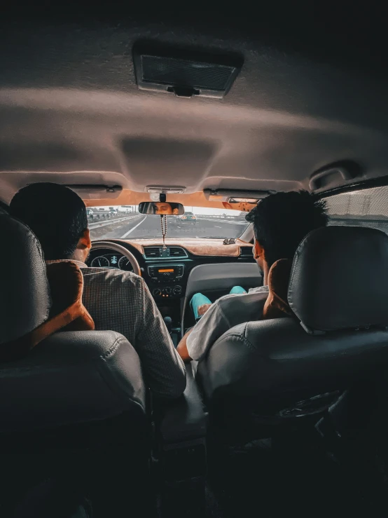 two people sitting in the back seat of a vehicle