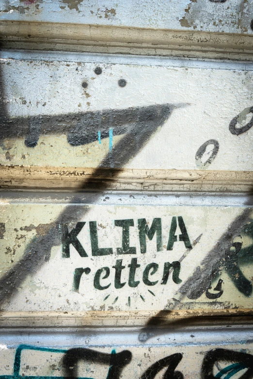 graffiti on a concrete wall that says klima rotten
