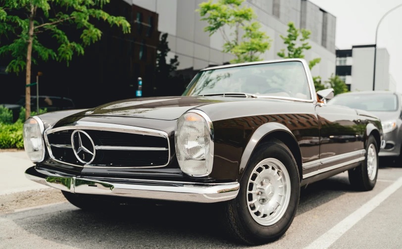 a mercedes - benz automobile on a street near a building