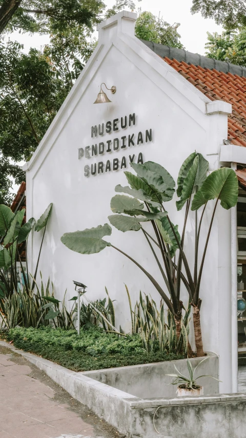museum on susaan surbaya on one side of road with trees and shrubbery