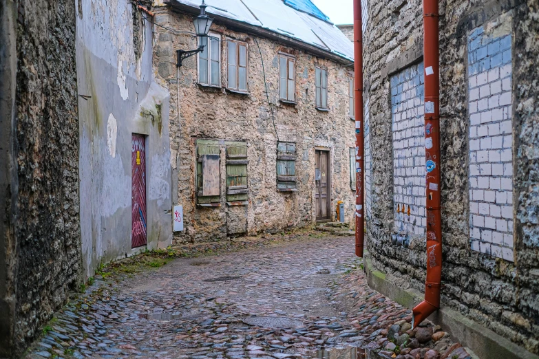 a cobblestone street leading to a two story brick building