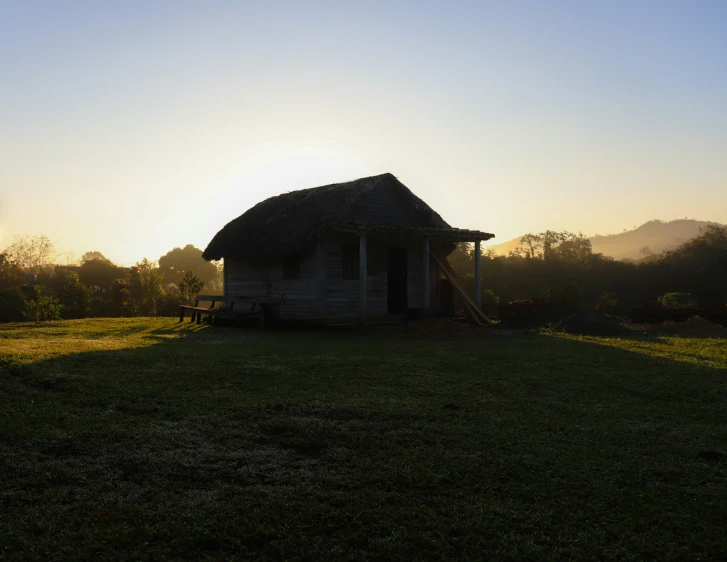 a small rustic house sits on a green lawn