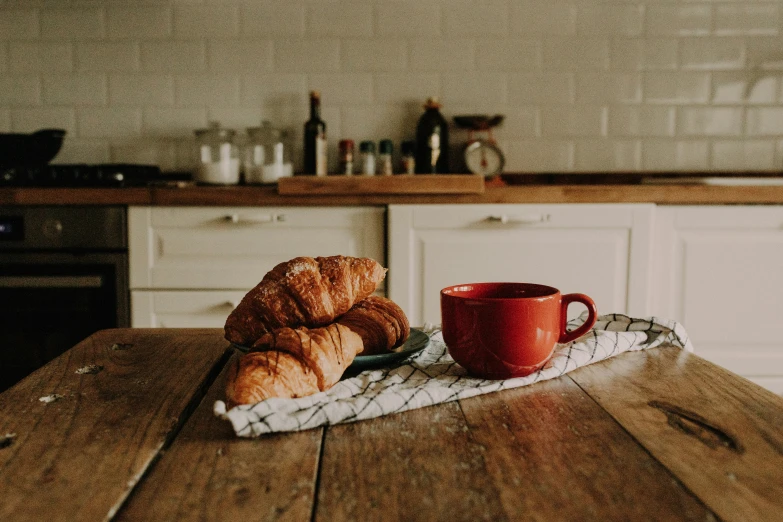 croissants and a mug sit on a kitchen table