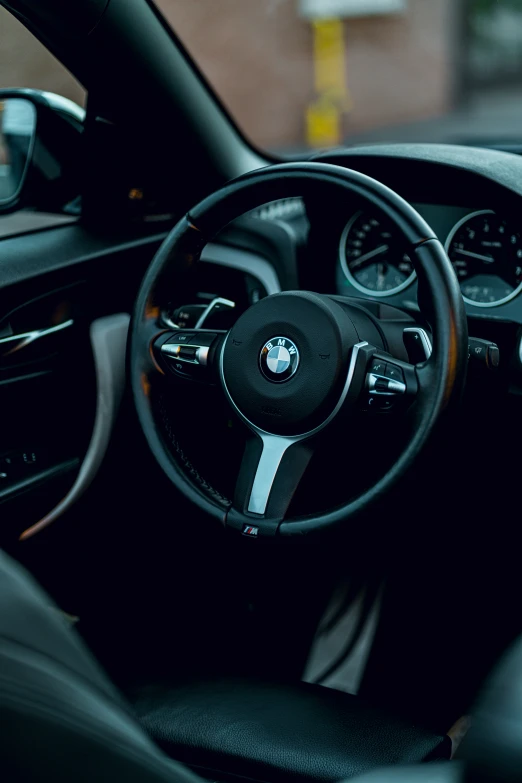 a black steering wheel inside a bmw car