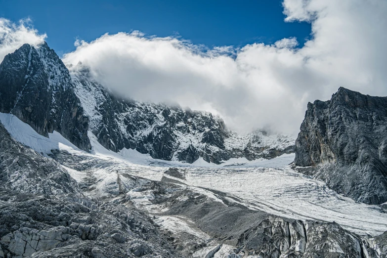 some mountains are shown from the ground under some clouds