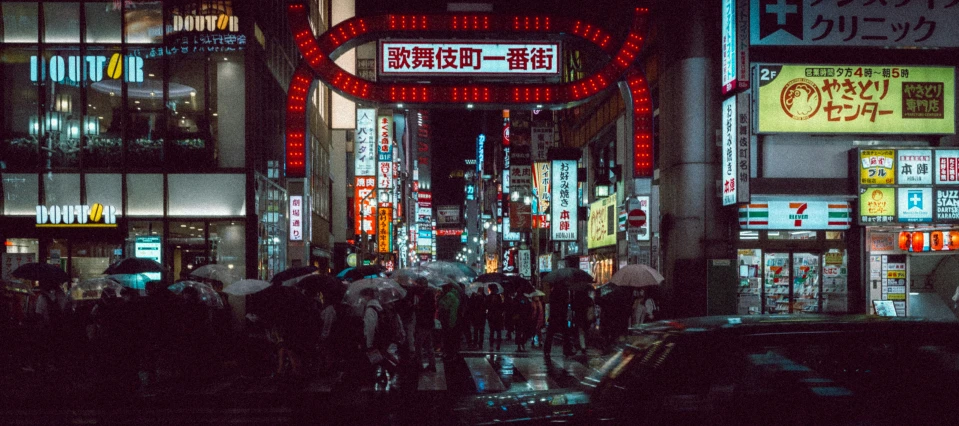 an asian street with people carrying umbrellas and cars