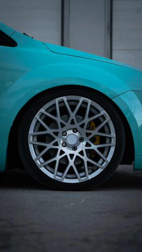 the rear end of a car that has been painted turquoise