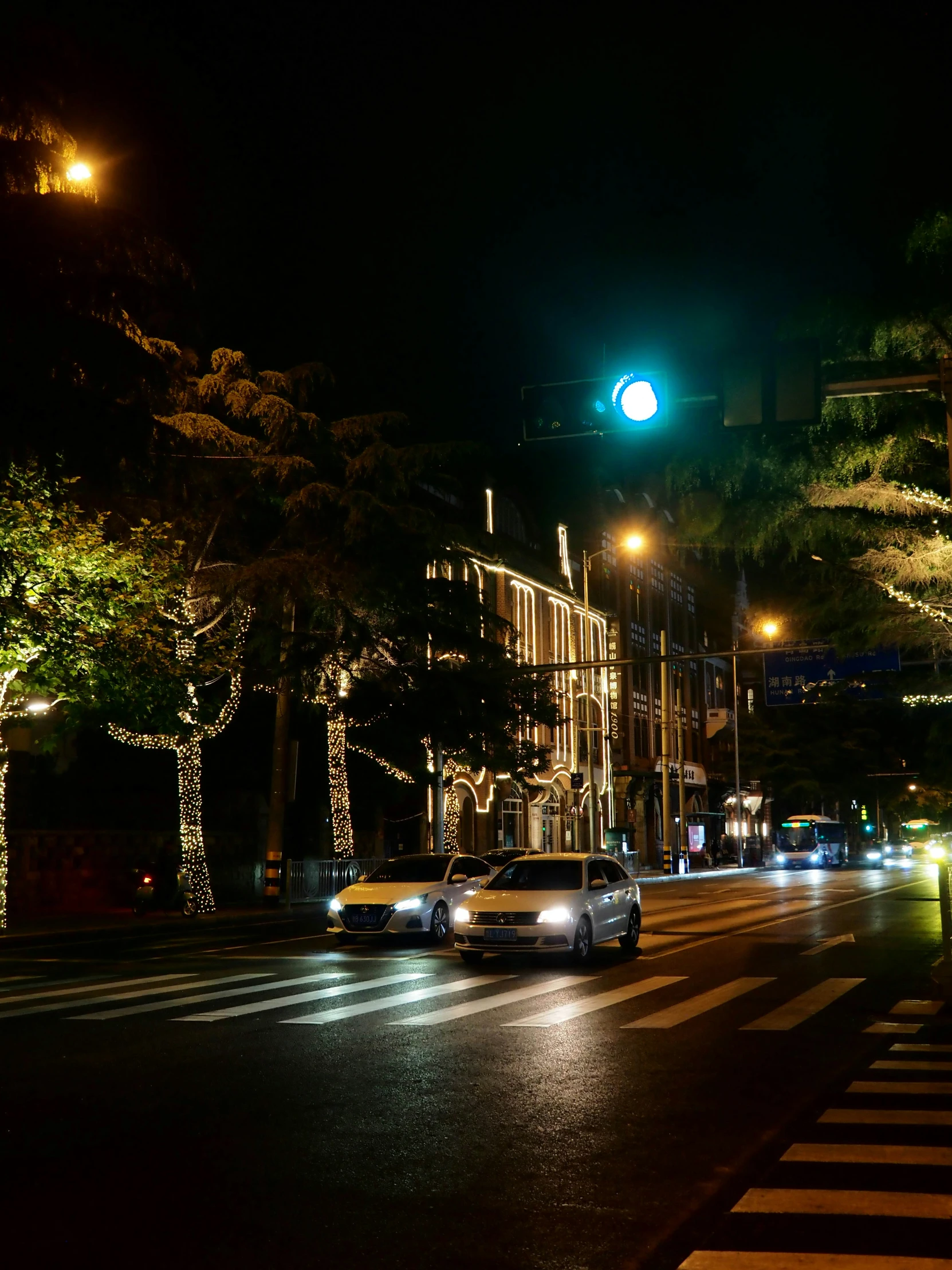 cars are stopped at an intersection at night time