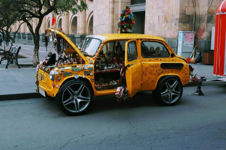 a yellow jeep with a large engine is parked by a bus