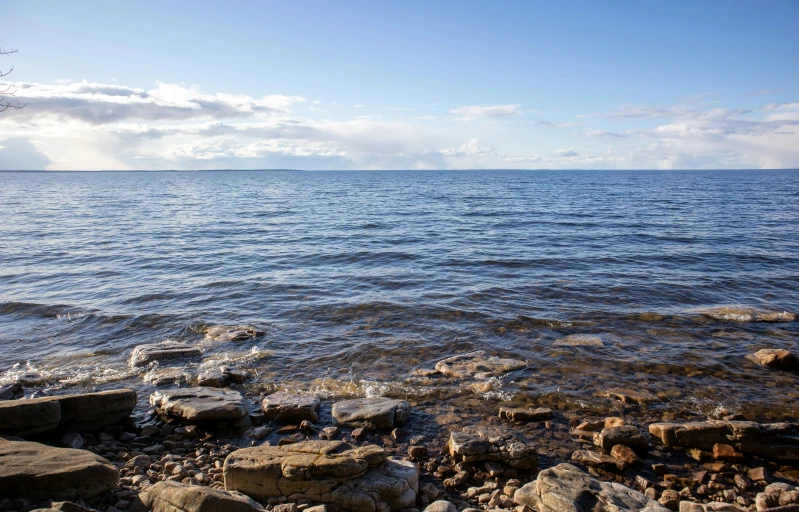 the rocks are sitting in the water on the shore