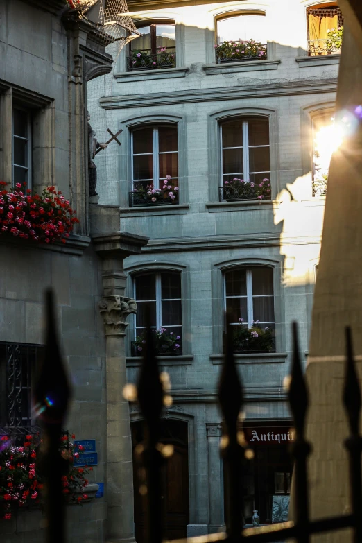 the windows of a building are open with flower boxes on the ledges