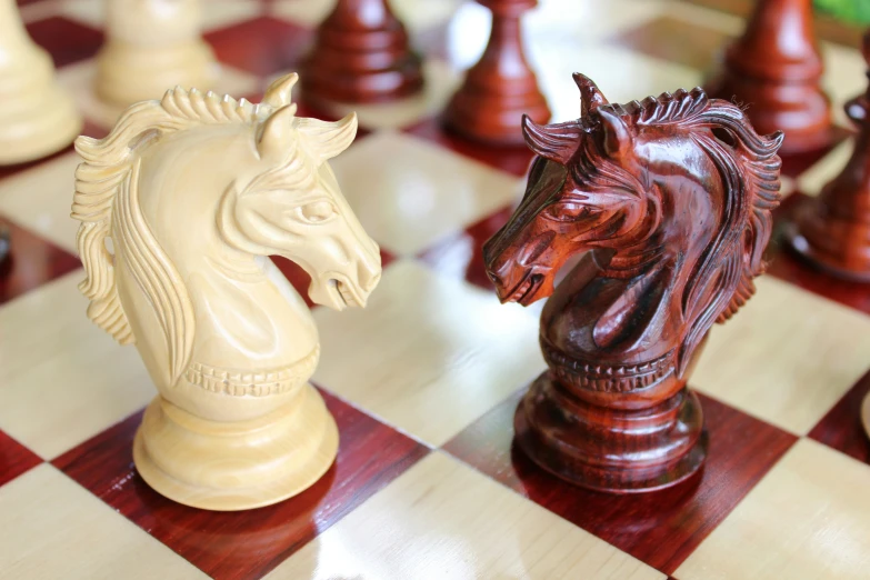 a wooden chess board with a horse carving on the top
