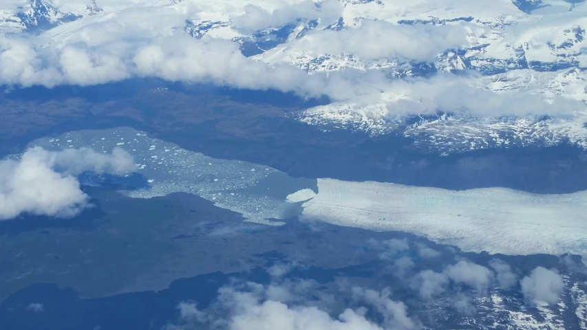 a view from an airplane of a mountain with snow and ice