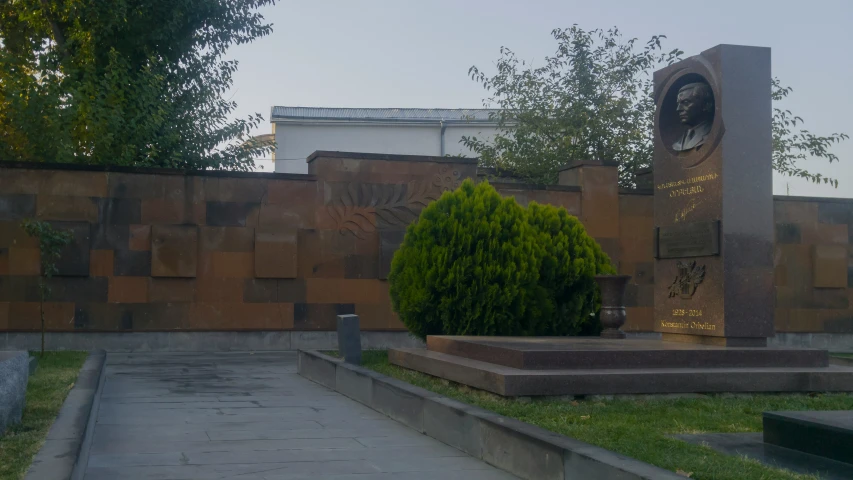 a monument with a statue and flowers on it