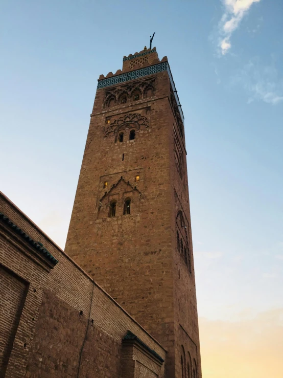 a tall brick clock tower sitting next to a wall