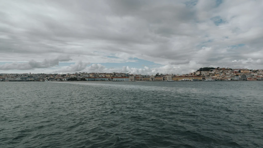 the clouds are fluffy above the city along the ocean