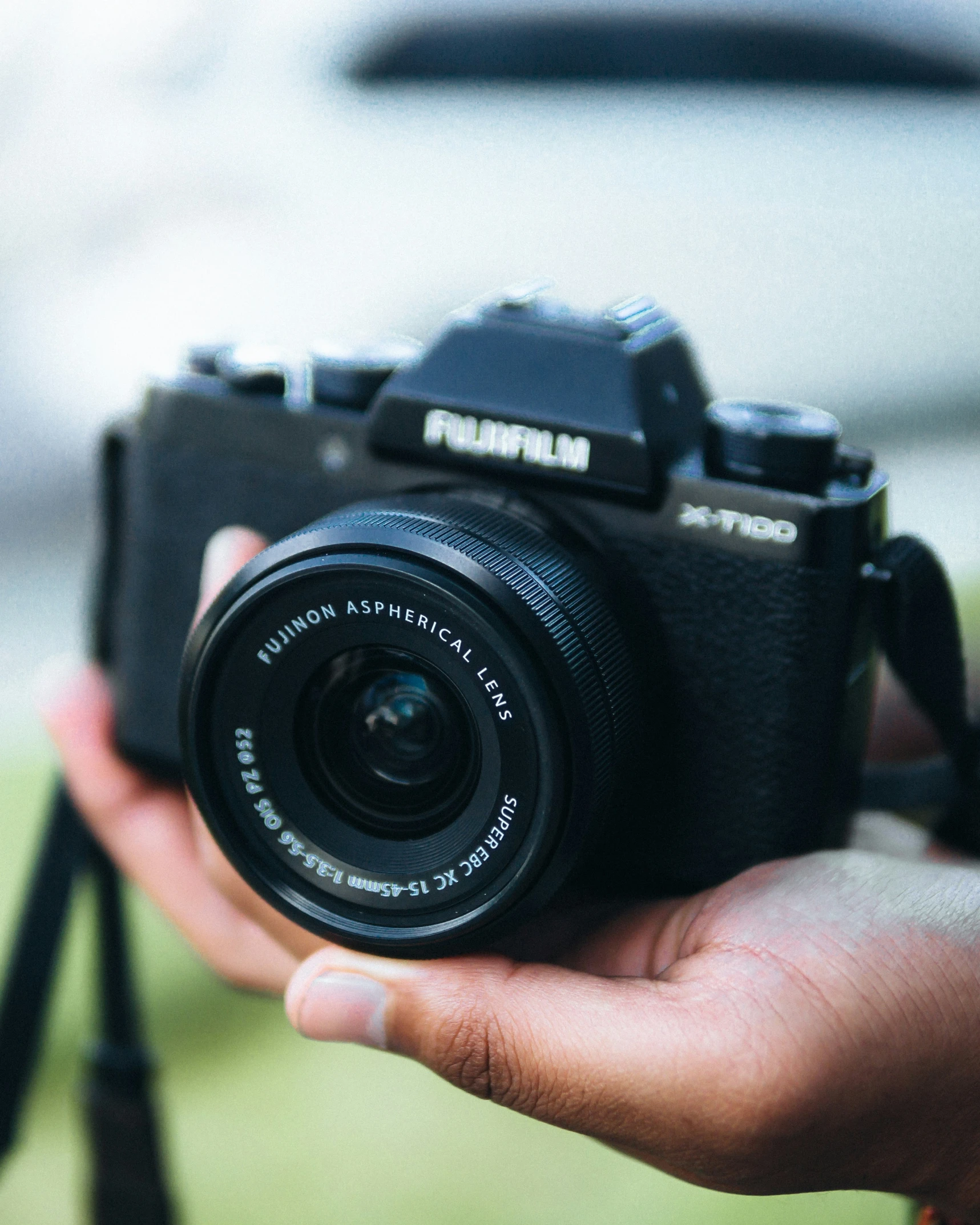 a hand is holding a digital camera in front of the lens