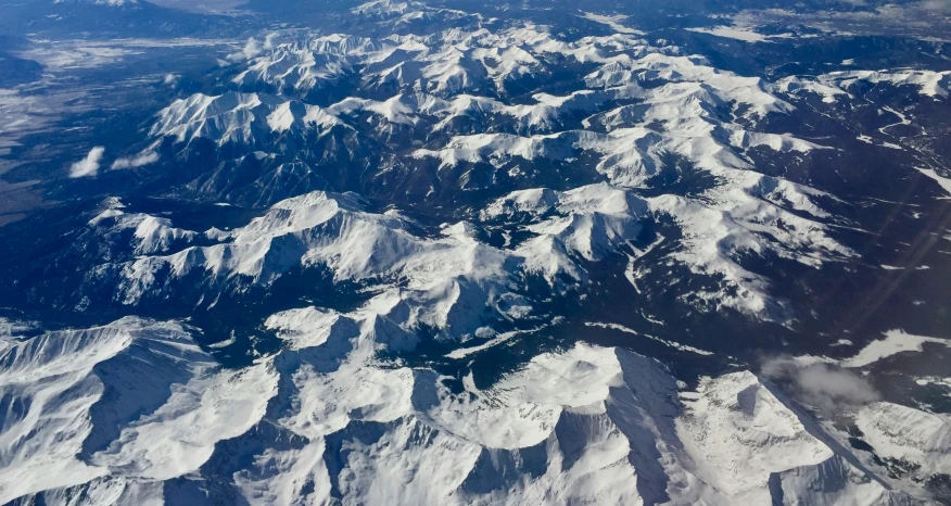 an aerial view of mountains and snow capped land