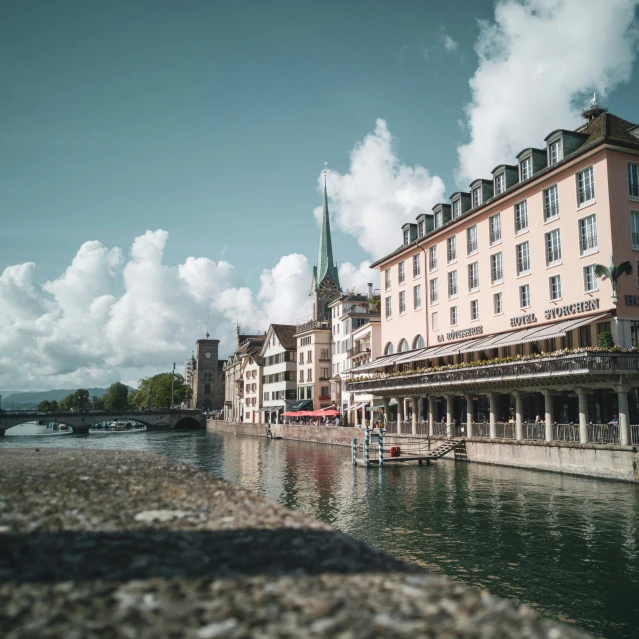 a building next to the water near some houses