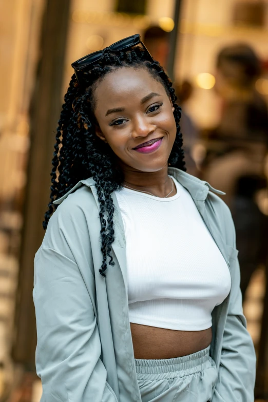 a woman in gray and white smiles as she stands outside