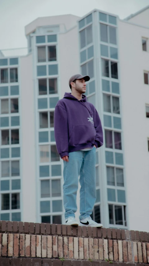 the man is standing on top of the brick pillar