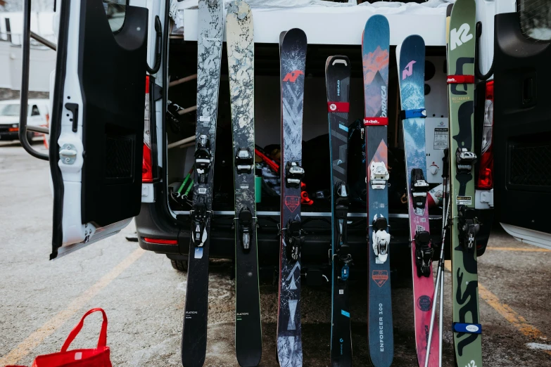 a van loaded with skis and snowboards in the parking lot